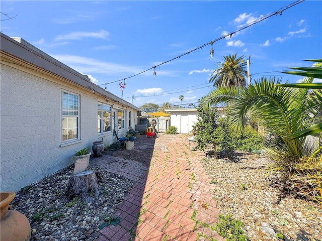 view of yard featuring a patio area, an outdoor structure, and fence