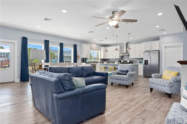 living room featuring light hardwood / wood-style floors and ceiling fan