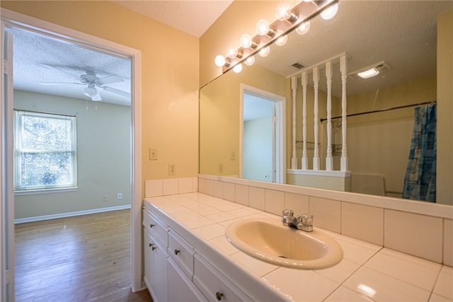 bathroom featuring vanity, wood-type flooring, a textured ceiling, and ceiling fan