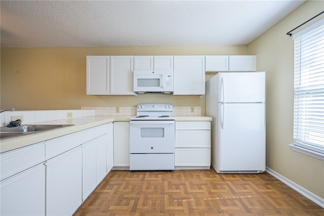 kitchen featuring white cabinets, white appliances, dark parquet floors, and sink