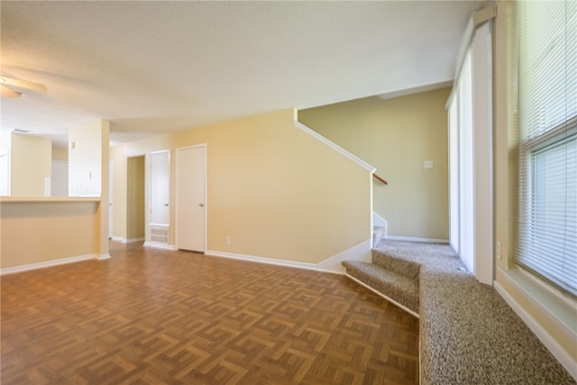 spare room with dark parquet flooring and a textured ceiling