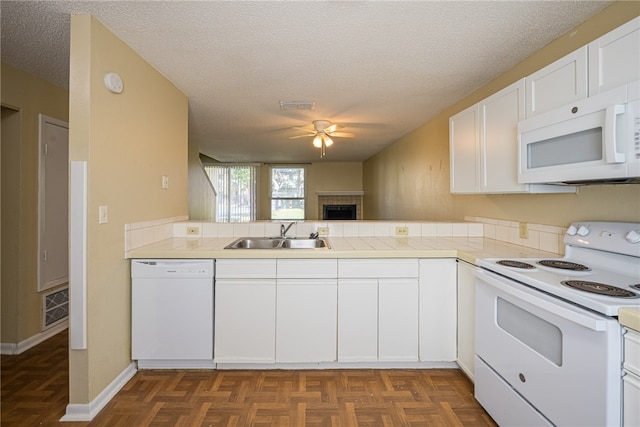 kitchen featuring white cabinetry, sink, kitchen peninsula, a textured ceiling, and white appliances