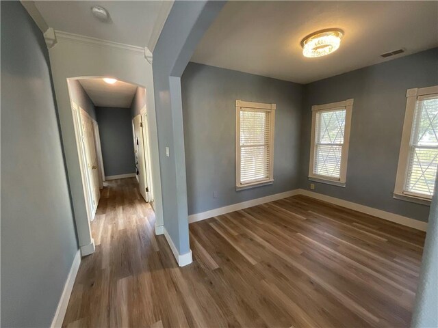 empty room with a ceiling fan, visible vents, wood finished floors, and baseboards