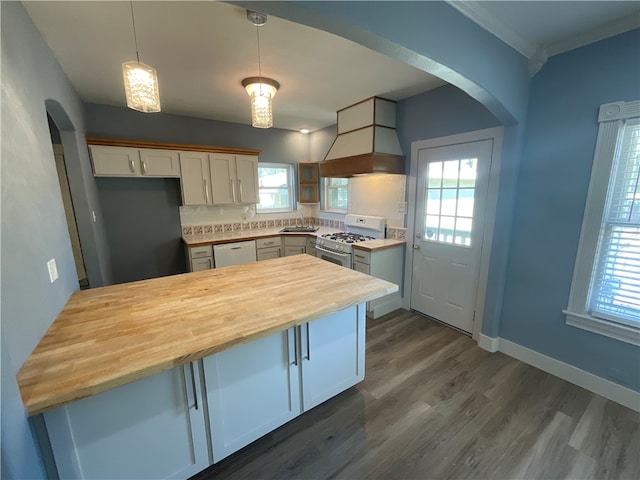 kitchen featuring white appliances, custom exhaust hood, arched walkways, and wood counters