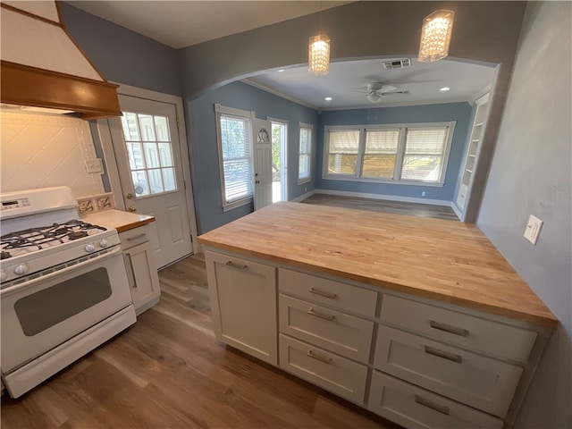 kitchen featuring visible vents, ceiling fan, custom range hood, wood counters, and white gas range