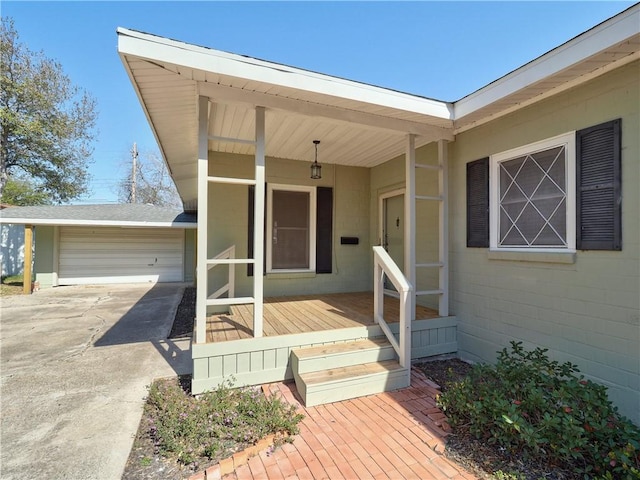 entrance to property featuring an attached garage, concrete block siding, and driveway