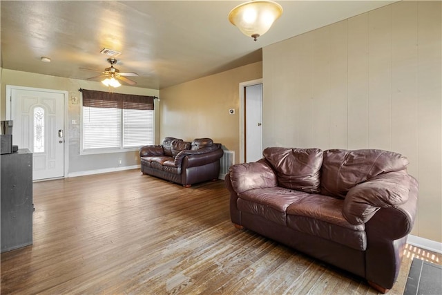living room with baseboards, ceiling fan, visible vents, and wood finished floors