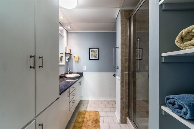 4600 Ocean Dr Unit 505, Corpus Christi, TX 78412 - bathroom with double vanity, a stall shower, tile patterned floors, and wainscoting