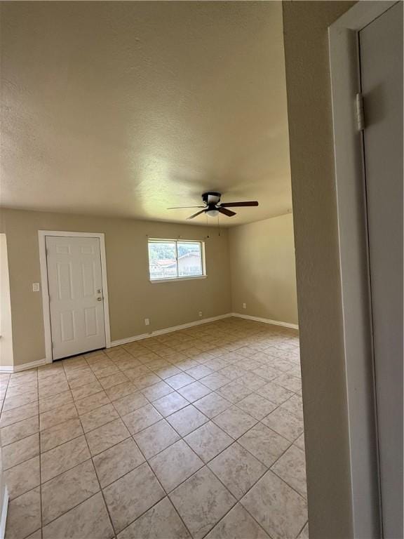1005 Schallert Dr, Alice, TX 78332 - spare room with a ceiling fan, light tile patterned floors, baseboards, and a textured ceiling