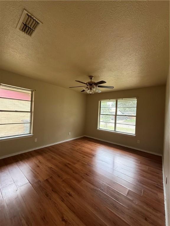 1005 Schallert Dr, Alice, TX 78332 - empty room with a textured ceiling, wood finished floors, a ceiling fan, and baseboards