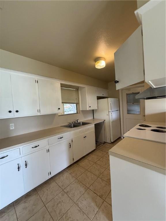 1005 Schallert Dr, Alice, TX 78332 - kitchen with freestanding refrigerator, a sink, white cabinets, and light tile patterned floors