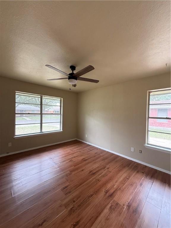 1005 Schallert Dr, Alice, TX 78332 - unfurnished room featuring ceiling fan, plenty of natural light, dark wood-type flooring, baseboards, and a textured ceiling