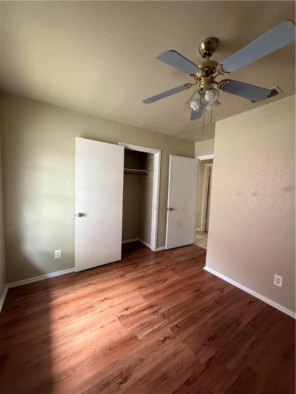 1005 Schallert Dr, Alice, TX 78332 - unfurnished bedroom with wood finished floors, baseboards, and a closet