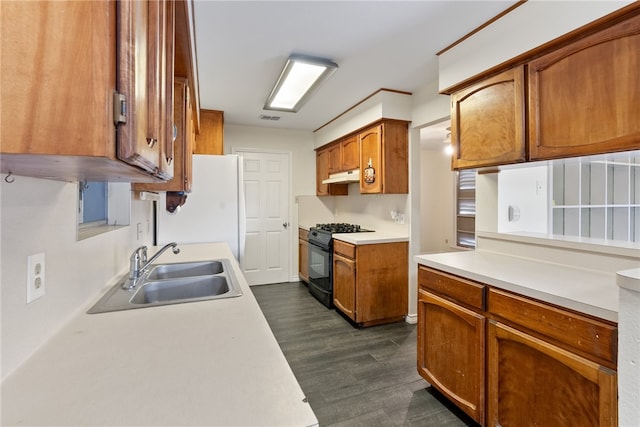 kitchen with black range with gas stovetop, dark hardwood / wood-style floors, sink, and white refrigerator