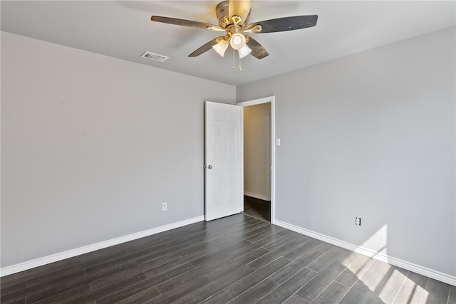 empty room with ceiling fan and dark hardwood / wood-style flooring