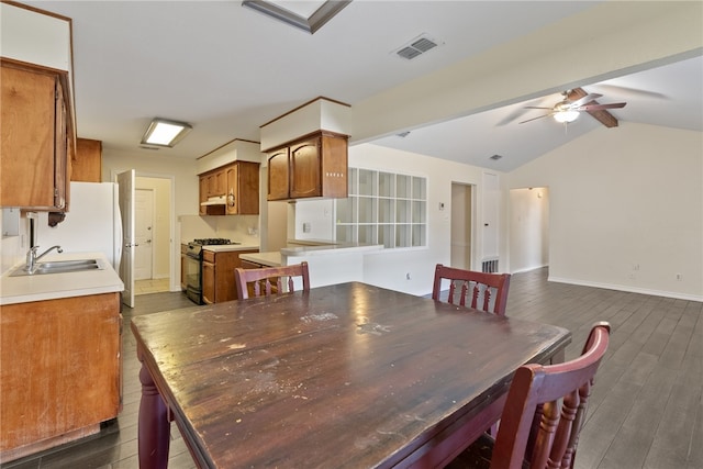 dining space featuring vaulted ceiling with beams, sink, dark hardwood / wood-style floors, and ceiling fan