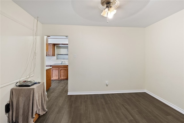 spare room with dark wood-type flooring, ceiling fan, and sink