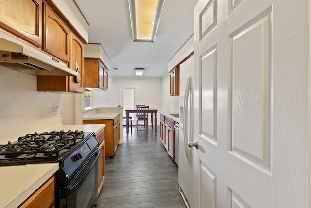 kitchen featuring black gas range, dark wood-type flooring, and dishwasher