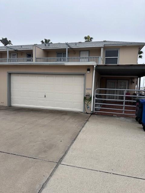 townhome / multi-family property featuring driveway, an attached garage, and stucco siding