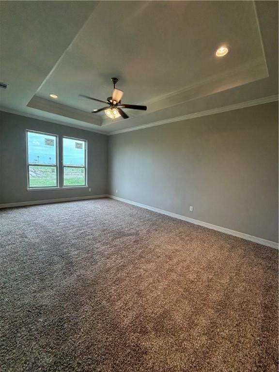 carpeted empty room featuring baseboards, a tray ceiling, and crown molding