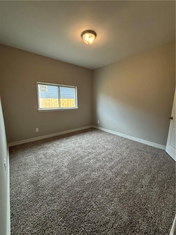 carpeted spare room with baseboards