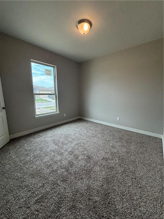 empty room featuring baseboards and carpet flooring