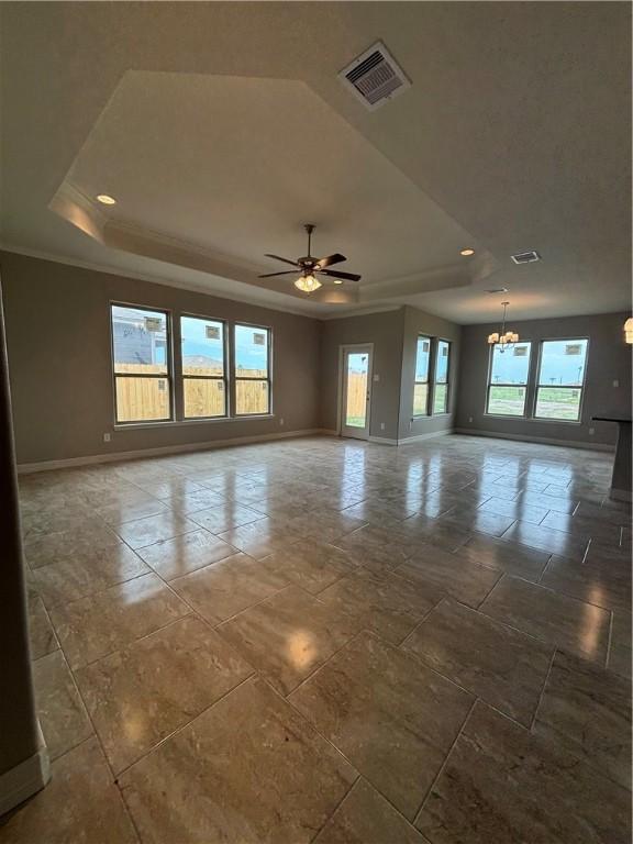 spare room featuring a raised ceiling, visible vents, baseboards, and ceiling fan with notable chandelier