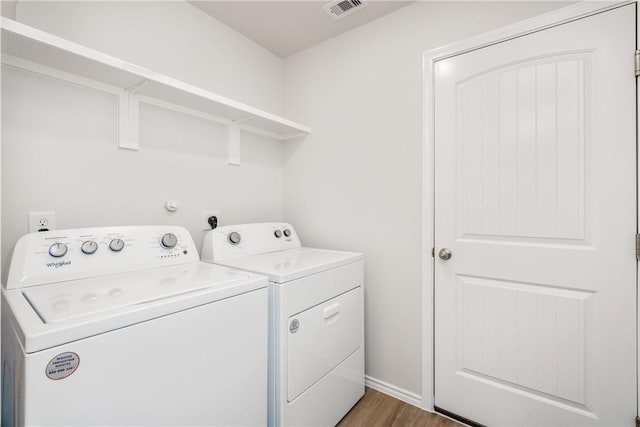 laundry area featuring laundry area, visible vents, separate washer and dryer, and wood finished floors