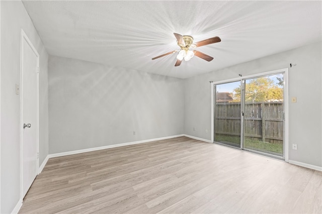 empty room with ceiling fan and light hardwood / wood-style flooring