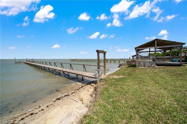dock area with a gazebo, a water view, and a yard
