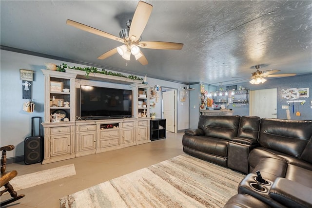 living room featuring a ceiling fan, ornamental molding, and finished concrete flooring