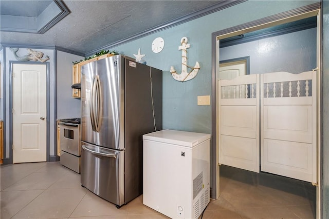 kitchen with light tile patterned floors, light countertops, crown molding, and stainless steel appliances