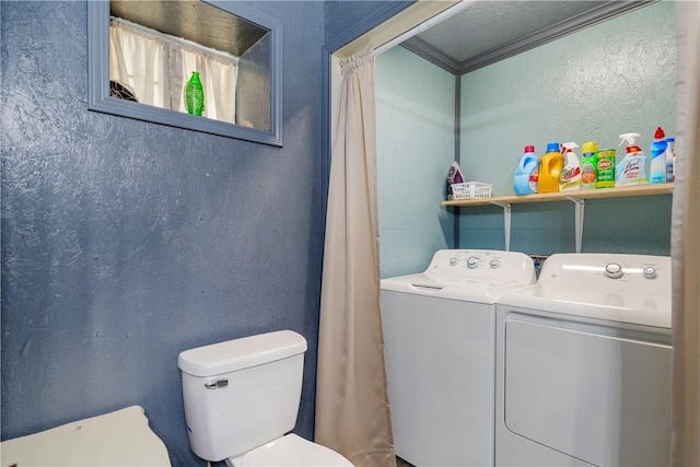 bathroom featuring toilet and washing machine and clothes dryer
