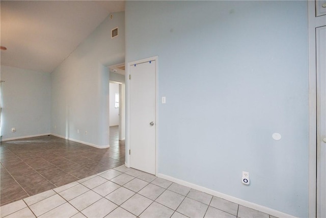 tiled empty room with vaulted ceiling