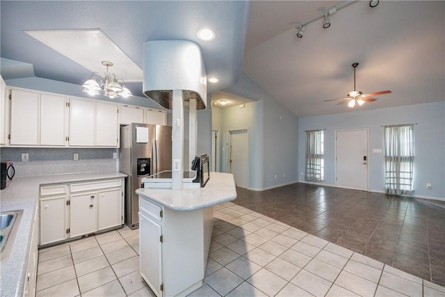 kitchen with stainless steel fridge, light tile patterned flooring, ceiling fan with notable chandelier, and white cabinetry