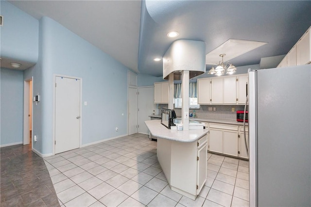 kitchen with white cabinetry, stainless steel fridge, decorative backsplash, hanging light fixtures, and a kitchen island