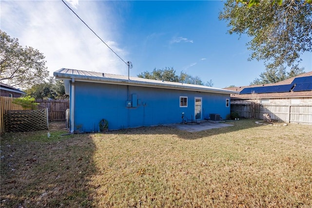 back of house featuring a lawn and central air condition unit