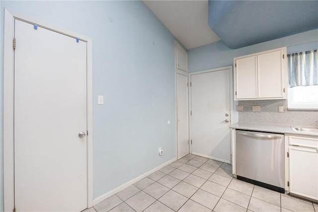 kitchen with white cabinets, dishwasher, tasteful backsplash, sink, and light tile patterned floors