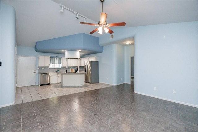 unfurnished living room with vaulted ceiling, ceiling fan, rail lighting, and tile patterned floors