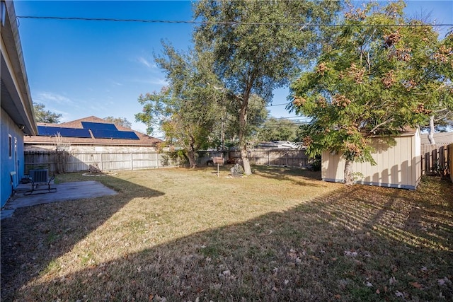 view of yard featuring a storage shed and central AC unit