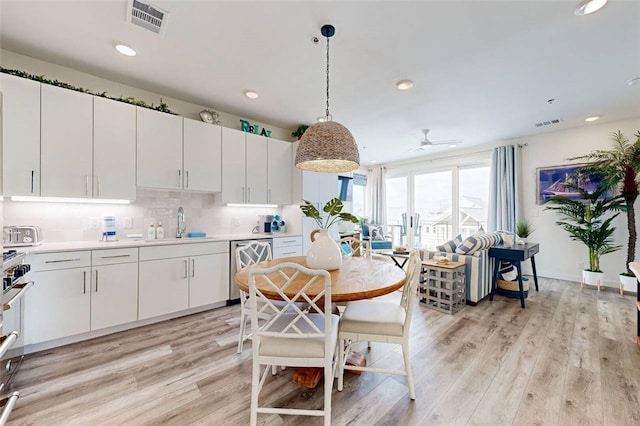 kitchen featuring white cabinetry, light hardwood / wood-style flooring, hanging light fixtures, and ceiling fan