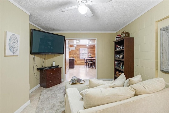 living room with a textured ceiling, ceiling fan, crown molding, and wood walls