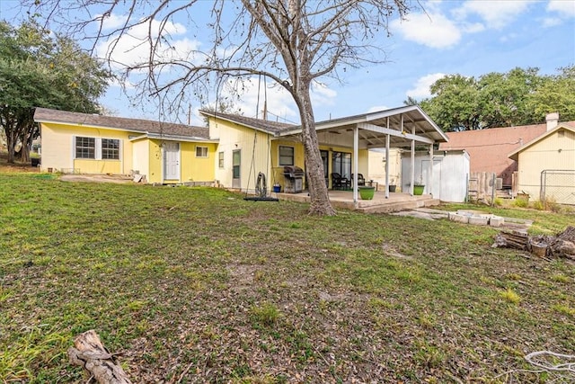 back of property featuring a lawn and a patio