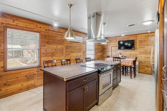 kitchen featuring a center island, wood walls, island exhaust hood, and stainless steel appliances