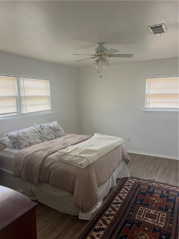 3023 66th St, Lubbock, TX 79413 - bedroom featuring wood finished floors, a ceiling fan, and baseboards