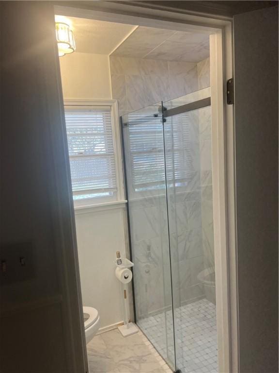 3023 66th St, Lubbock, TX 79413 - full bathroom with marble look tile flooring, toilet, and a stall shower