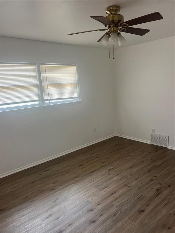3023 66th St, Lubbock, TX 79413 - unfurnished room featuring dark wood-type flooring, a ceiling fan, and baseboards