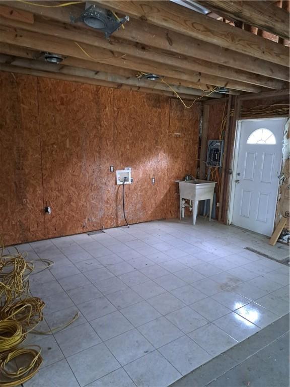 basement featuring wooden walls and a sink