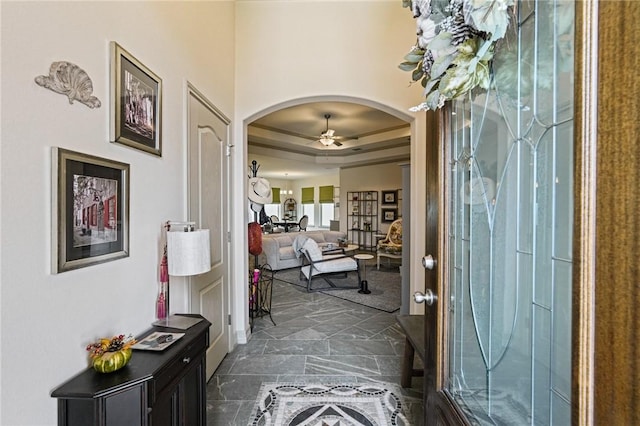 entrance foyer featuring ceiling fan and a tray ceiling