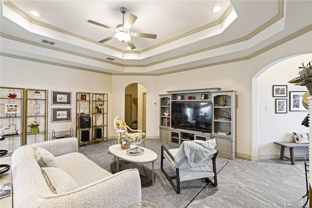 living room with crown molding, a raised ceiling, and ceiling fan